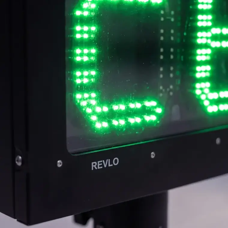 Dígitos de LED verde da lombada educativa vistos de perto, atrás do vidro do gabinete